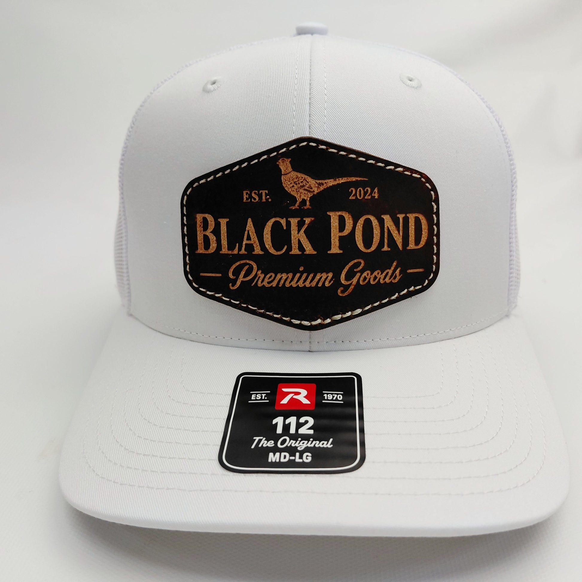 Front view of all-white Black Pond pheasant leather patch Richardson 112 trucker hat