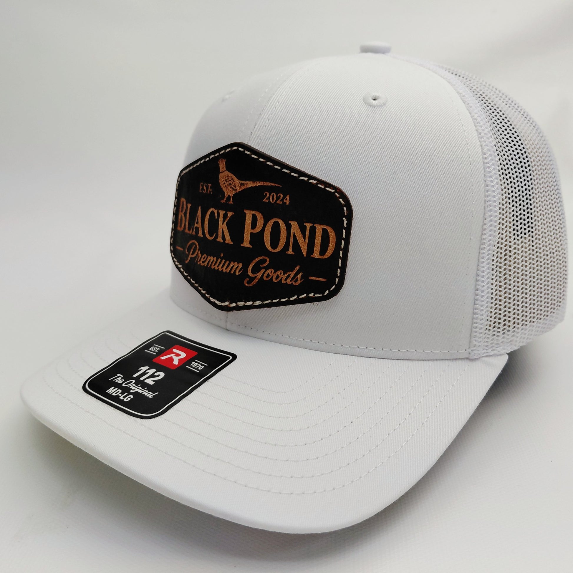 Left angled view of all-white Black Pond pheasant leather patch Richardson 112 hat