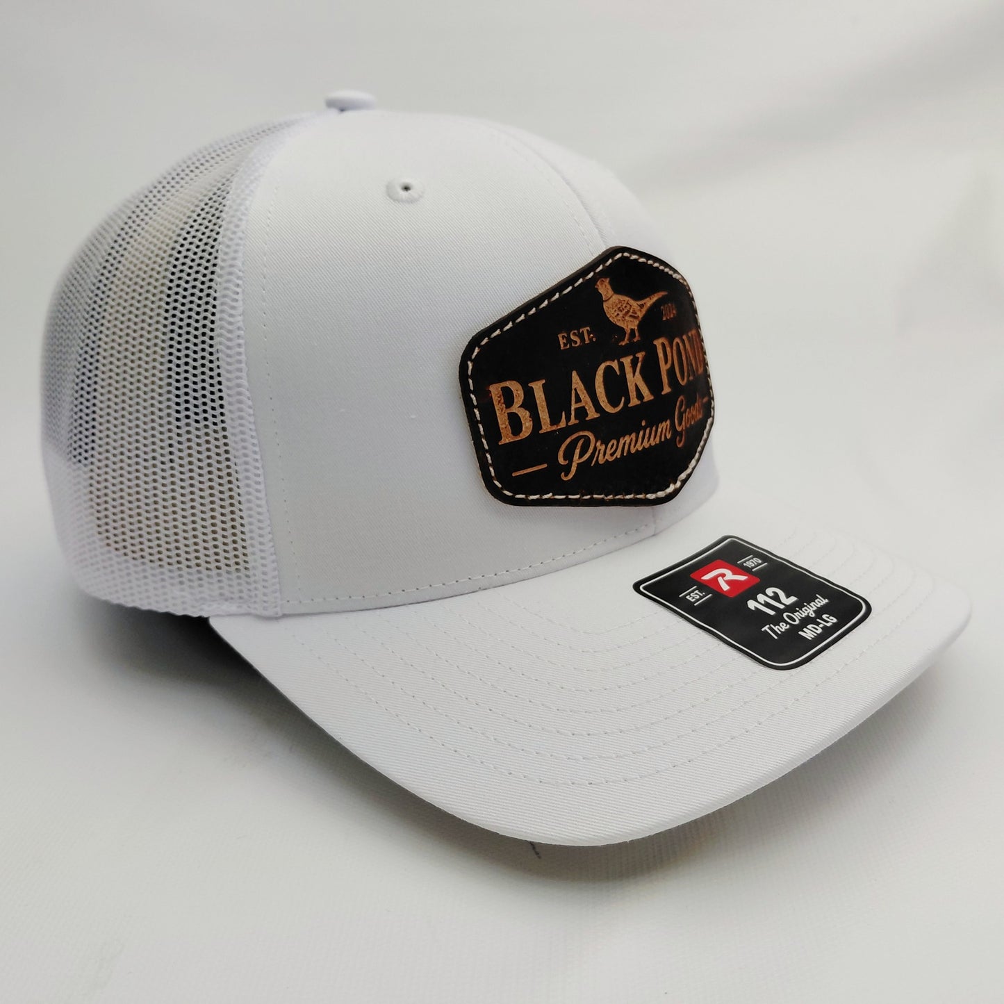 Right angled view of all-white Black Pond pheasant leather patch Richardson 112 hat