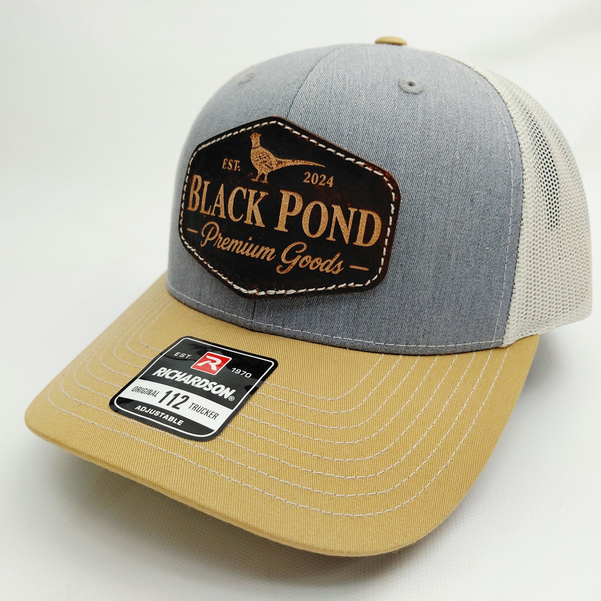 Left angled view of Black Pond pheasant leather patch Richardson 112 trucker hat