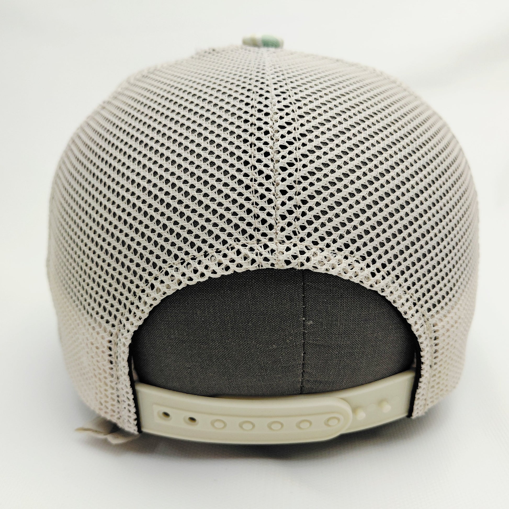 Cream mesh back and adjustable snap closure of Black Pond mint orange camouflage trucker hat