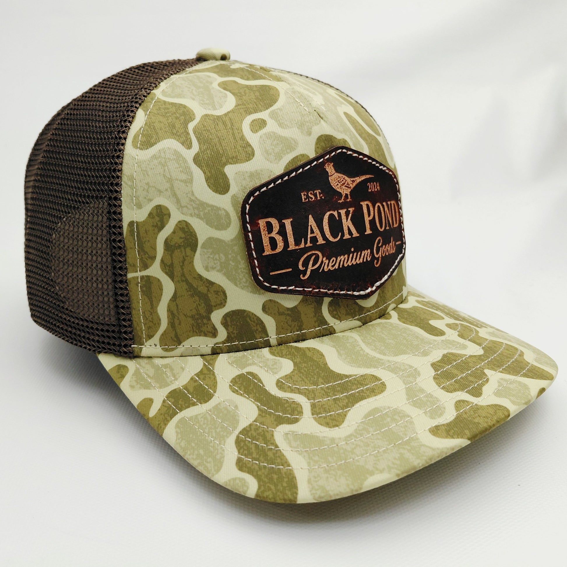 Right angled view of Black Pond pheasant leather patch Richardson 112 camouflage trucker hat