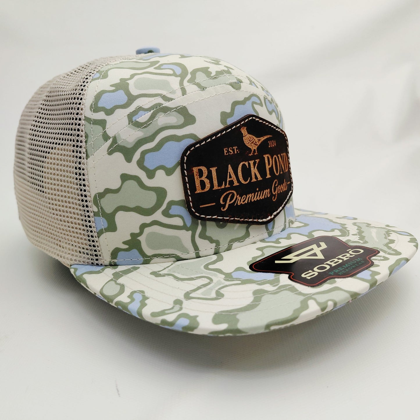 Right angled view of Black Pond pheasant leather patch SOBRO seven-panel camouflage trucker hat
