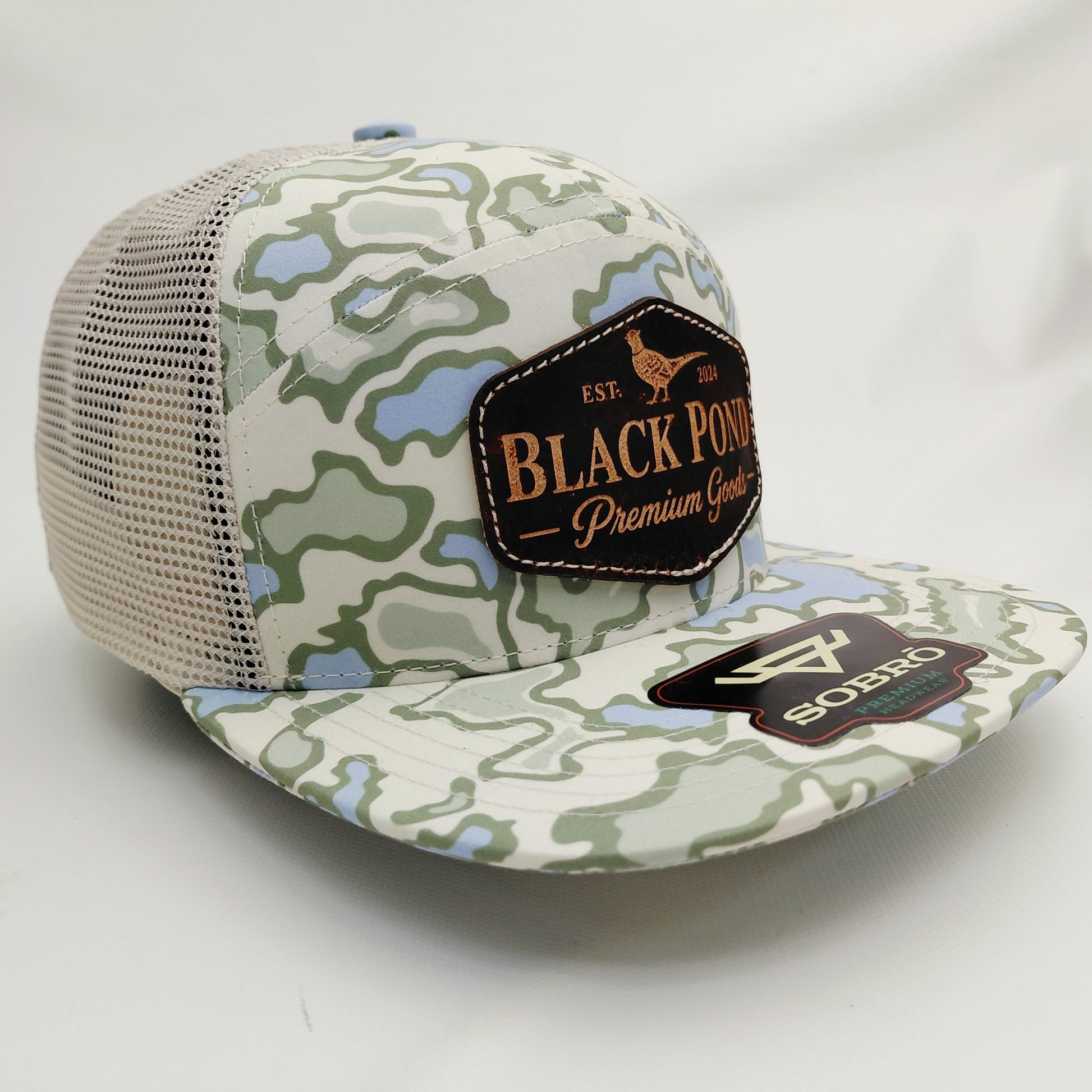 Right angled view of Black Pond pheasant leather patch SOBRO seven-panel camouflage trucker hat