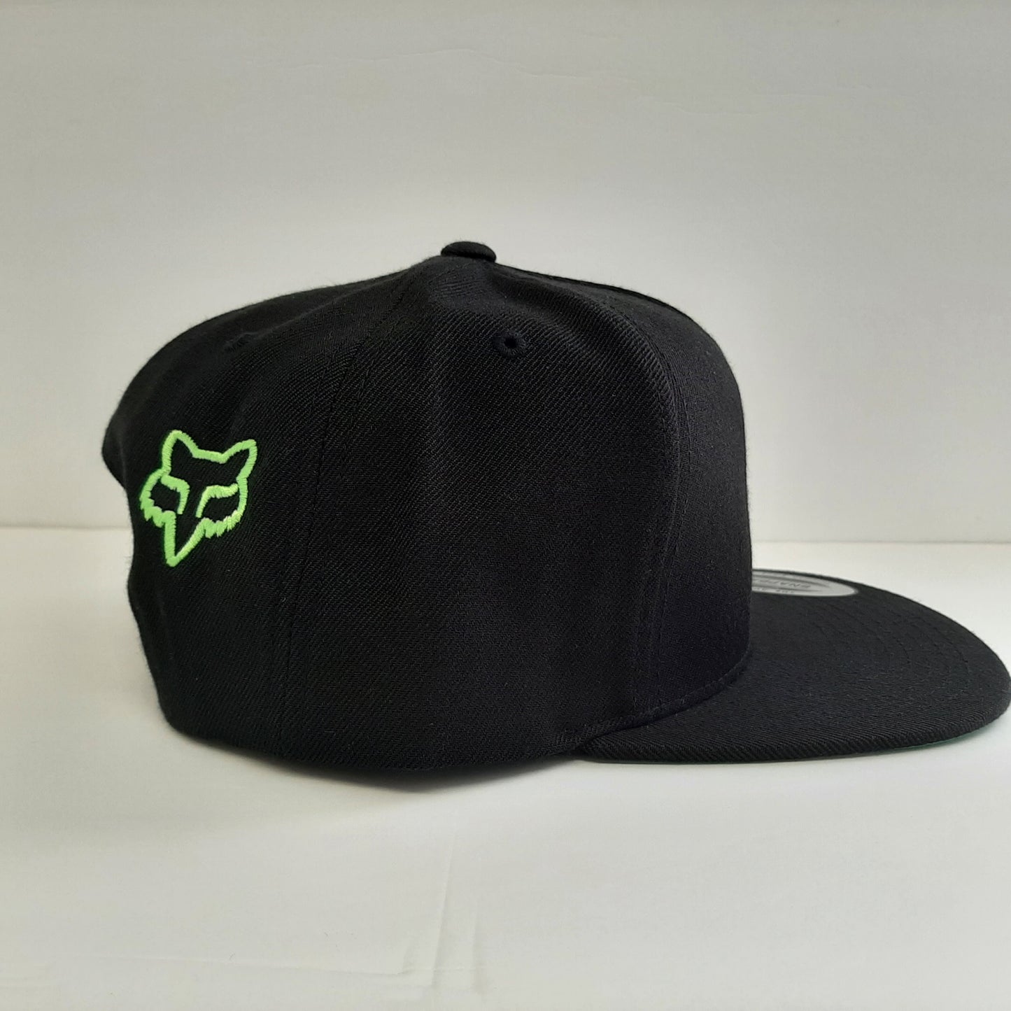 Has a Fox logo embroidered on the back right panel of the hat and the color matches the fluorescent green on the front of the cap.